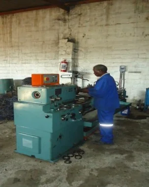 Engineers working on industrial machinery components in a workshop